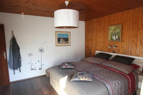 a bedroom with a bed in a room with wooden walls at Snežak (Snowman) in Bohinj