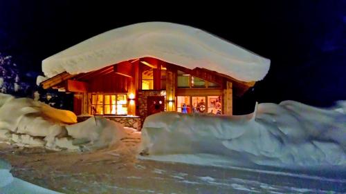 a log cabin covered in snow at night at Clubhotel Hinterthal Am Florysee 6 in Hinterthal
