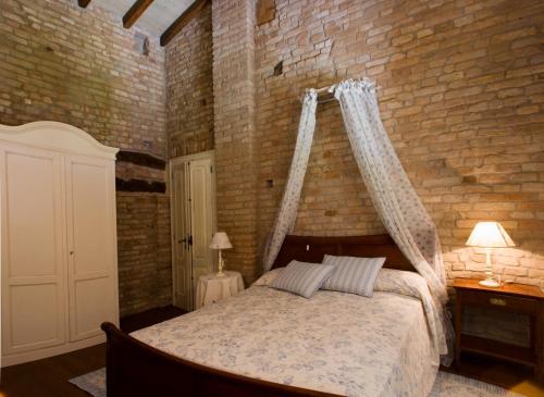 a bedroom with a bed and a brick wall at Hospitale I Mori in Asola