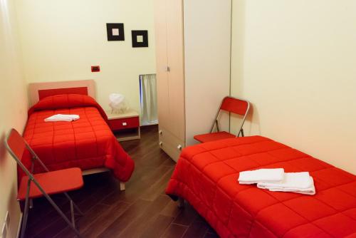 two beds in a room with red sheets at Una Casa al Belvedere in Enna