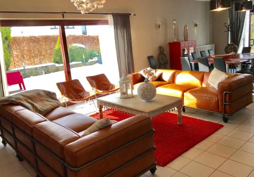 a living room with two leather couches and a table at Chalet Ardenne in Rochehaut