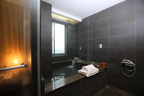 a bathroom with a sink and a tub with water at Shan-Yue Hotspring Hotel in Taipei