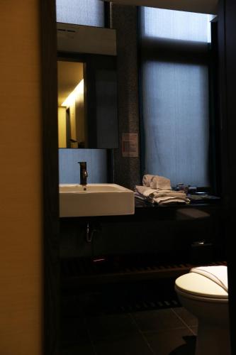 a bathroom with a sink and a toilet at Shan-Yue Hotspring Hotel in Taipei
