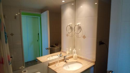 een badkamer met een wastafel en een spiegel bij Edificio Los Navegantes, Valparaiso in Valparaíso