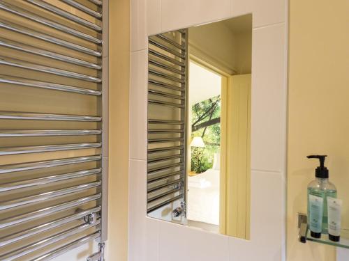 a bathroom with a mirror and a window at The Steppes Holiday Cottages in Hereford