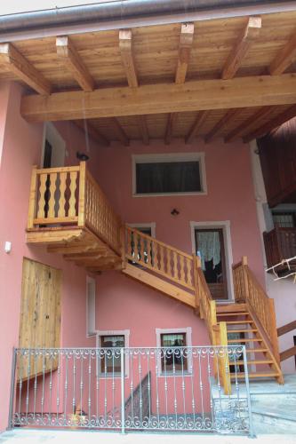a house with wooden stairs and a balcony at La Maison De Deni in Aymavilles
