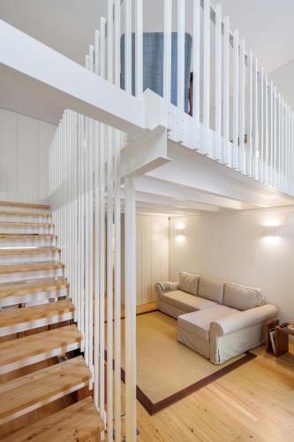 a living room with a couch and a staircase at Glory Days Lisbon Apartments in Lisbon