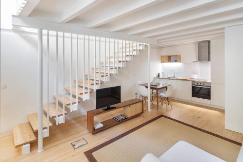 a living room with a television and a staircase at Glory Days Lisbon Apartments in Lisbon