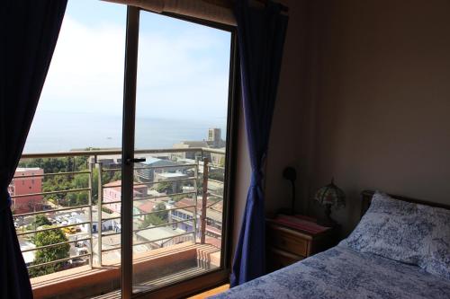 een slaapkamer met een bed en een groot raam bij Edificio Los Navegantes, Valparaiso in Valparaíso