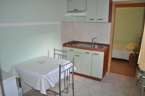 a small kitchen with a table and a sink at Apartments Zora in Vis