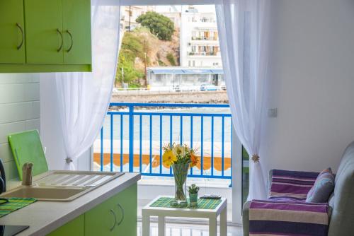 a kitchen with a balcony with a vase of flowers on a table at Sea View Apartments in Agios Nikolaos