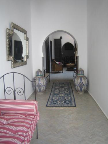 a living room with a couch and two mirrors at Dar Candal in Asilah
