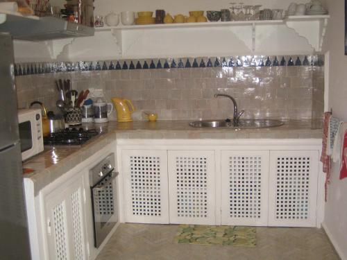 a kitchen with a sink and a microwave at Dar Candal in Asilah