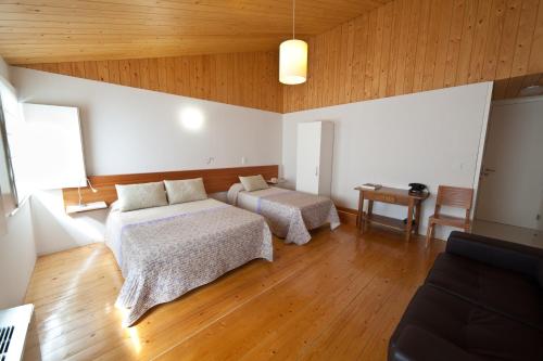 a large room with two beds and a table at A. Montesinho Turismo in Bragança