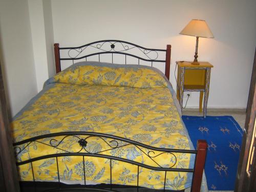 a bedroom with a bed with a yellow comforter at Dar Candal in Asilah