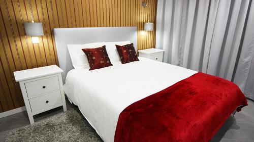 a bedroom with a large white bed and two night stands at Ferhouse Dreams in Nazaré