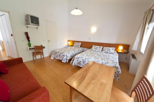 a living room with two beds and a table at A. Montesinho Turismo in Bragança