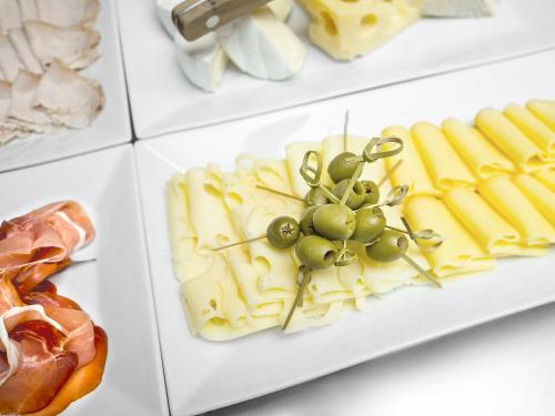 a plate of food with cheese and grapes on it at Wellness Hotel Happy Star in Hnanice