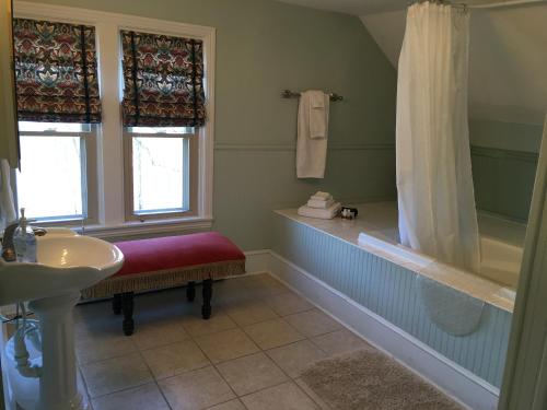 a bathroom with a shower and a bench and a sink at The Inn at Ragged Edge in Chambersburg