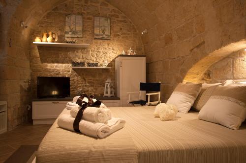 - une chambre avec 2 lits dans un mur en pierre dans l'établissement dormiRÈtrani, à Trani