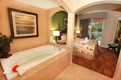 a hotel room with a tub and a bedroom at Mizner Place at Weston Town Center in Weston