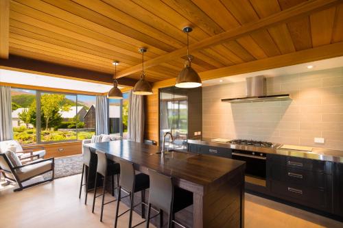 a kitchen with a large island with bar stools at Millbrook Resort in Arrowtown