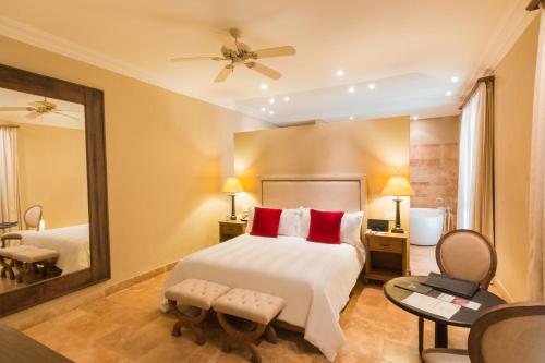 a bedroom with a large bed and a mirror at Bastión Luxury Hotel in Cartagena de Indias