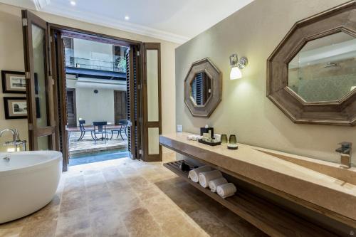 a bathroom with a tub and a large mirror at Bastión Luxury Hotel in Cartagena de Indias
