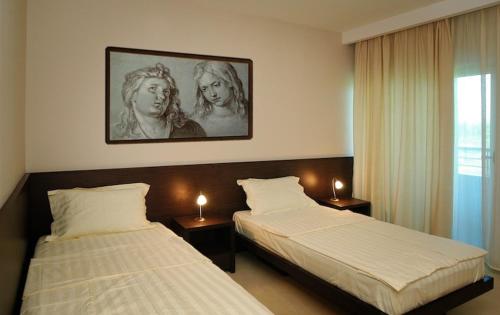 ein Schlafzimmer mit zwei Betten und ein Bild von zwei Frauen in der Unterkunft Hotel Golf Luxury in Kruševac