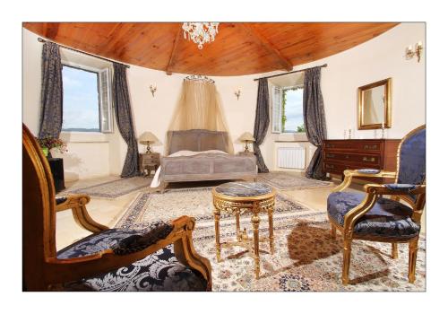 a living room with a bed and a table and chairs at Chateau de Mauras in Chomérac