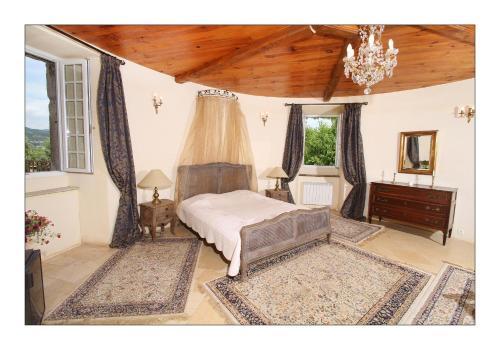 a bedroom with a bed and a chandelier at Chateau de Mauras in Chomérac