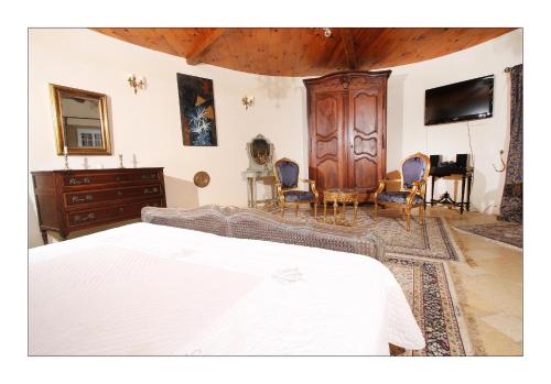a bedroom with a bed and a dresser at Chateau de Mauras in Chomérac
