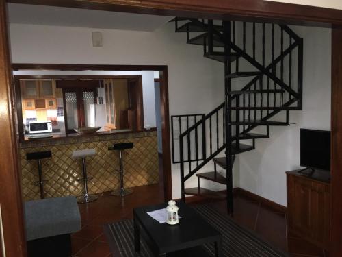 a living room with a spiral staircase and a table at DDS-Dominio das Sem&ntes in Vouzela