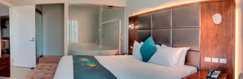 a bedroom with a large bed with a large headboard at The Palms Denarau Fiji in Denarau