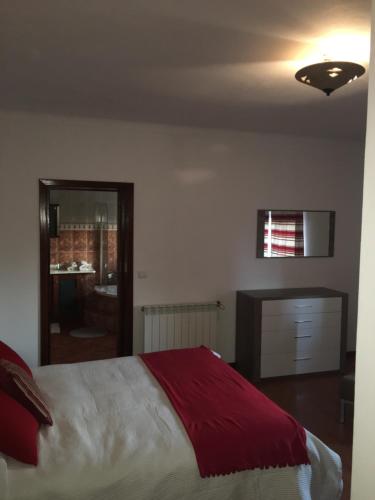 a bedroom with a large bed with a red blanket at DDS-Dominio das Sem&ntes in Vouzela