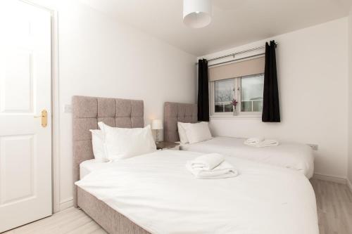 two beds in a bedroom with white sheets at Dunfermline - Premium Two Bedroom Apartment - KW in Dunfermline