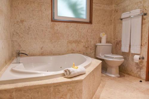 a bathroom with a bath tub and a toilet at Luxury Oceanview Condo 2 BR/2.5 BA in Sosúa