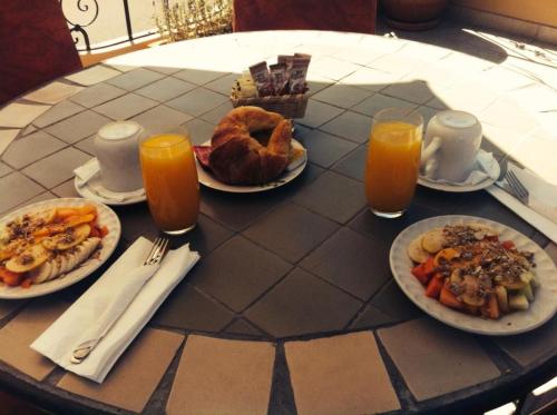 a table with plates of food and glasses of orange juice at Casa del Tio Hotel Boutique in San Miguel de Allende