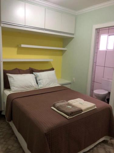 a bedroom with a large bed with a brown blanket at Hostel Trem de Minas in Belo Horizonte