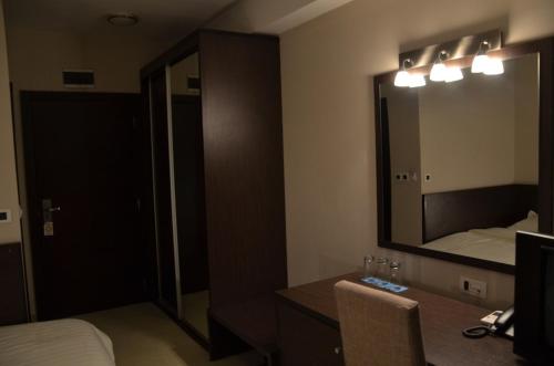 a hotel room with a large mirror and a bed at Hotel Golf Luxury in Kruševac