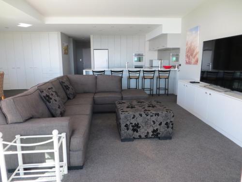 a living room with a couch and a kitchen at Cutterscove Resort Apartments in Mount Maunganui