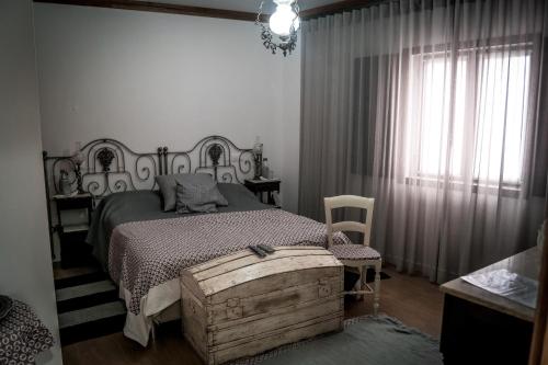 a bedroom with a bed and a table and a window at Quinta Manel da Gaita in Torres Novas