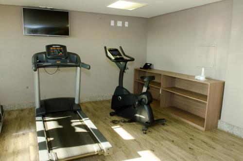 a room with a gym with a treadmill and a phone at Ville Celestine Hotel in Belo Horizonte