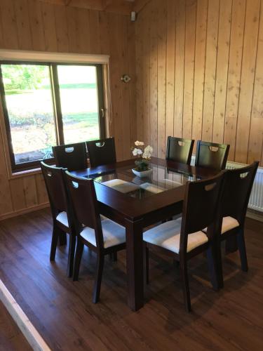 a dining room with a wooden table and chairs at Cabañas Peumayen in Puerto Varas