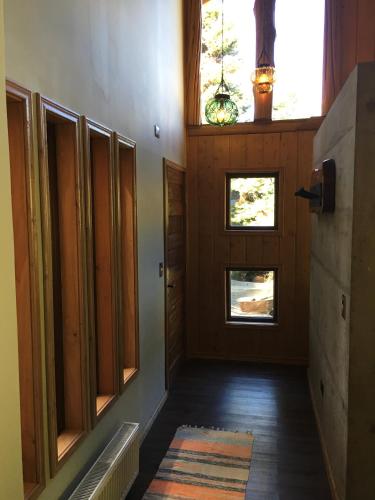 a hallway of a house with a door and windows at Cabañas Peumayen in Puerto Varas