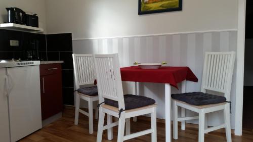 a kitchen with a table with two chairs and a red table at Pension Am Dorfanger in Hohennauen