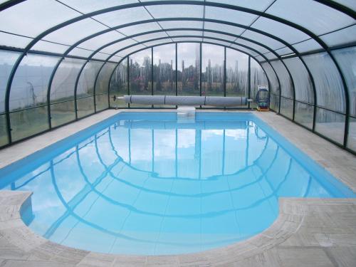 une piscine intérieure avec un dôme en verre dans l'établissement Maison Avec Piscine, à Plérin