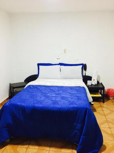 a blue and white bed in a room at Hotel Parkway Inn 58 Street in Bogotá