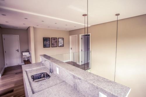 a bathroom with a sink and a glass wall at Pousada Native in Florianópolis