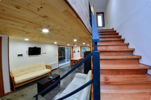 a room with a staircase with a couch and a table at Cabañas del pillan in Pucón